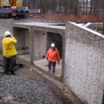 Workers inspecting culvert construction.